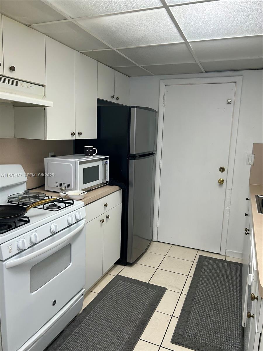 17901 Northwest 68th Avenue, Unit R209 Hialeah, FL 33015 - Photo 9 of 40 a kitchen with a stove top oven and refrigerator