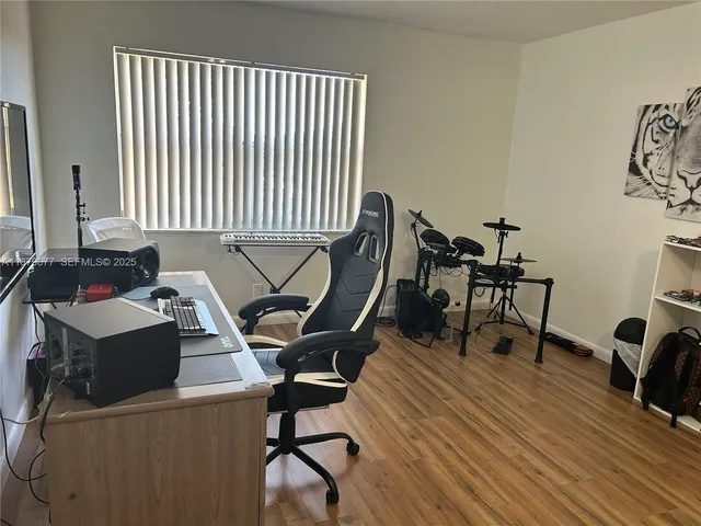 a view of a workspace with furniture and a window