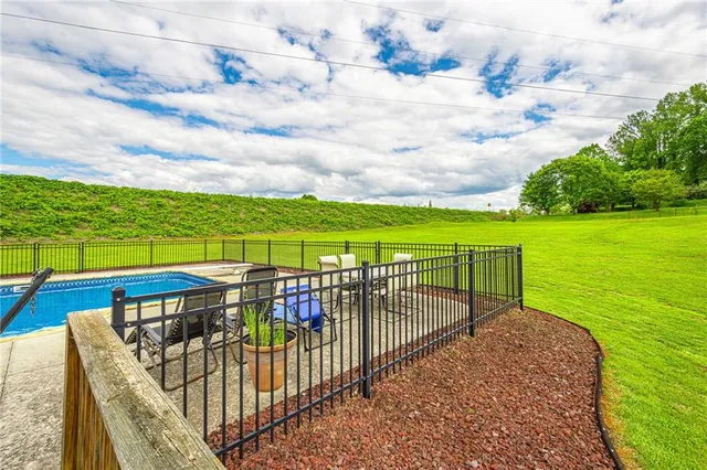 a view of a house with a big yard and swimming pool