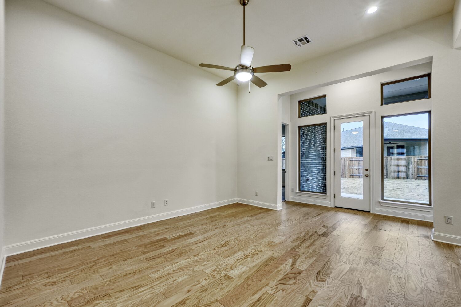 253 Prickly Poppy Loop Kyle, TX 78640 - Photo 3 of 11 a view of an empty room with a window and wooden floor