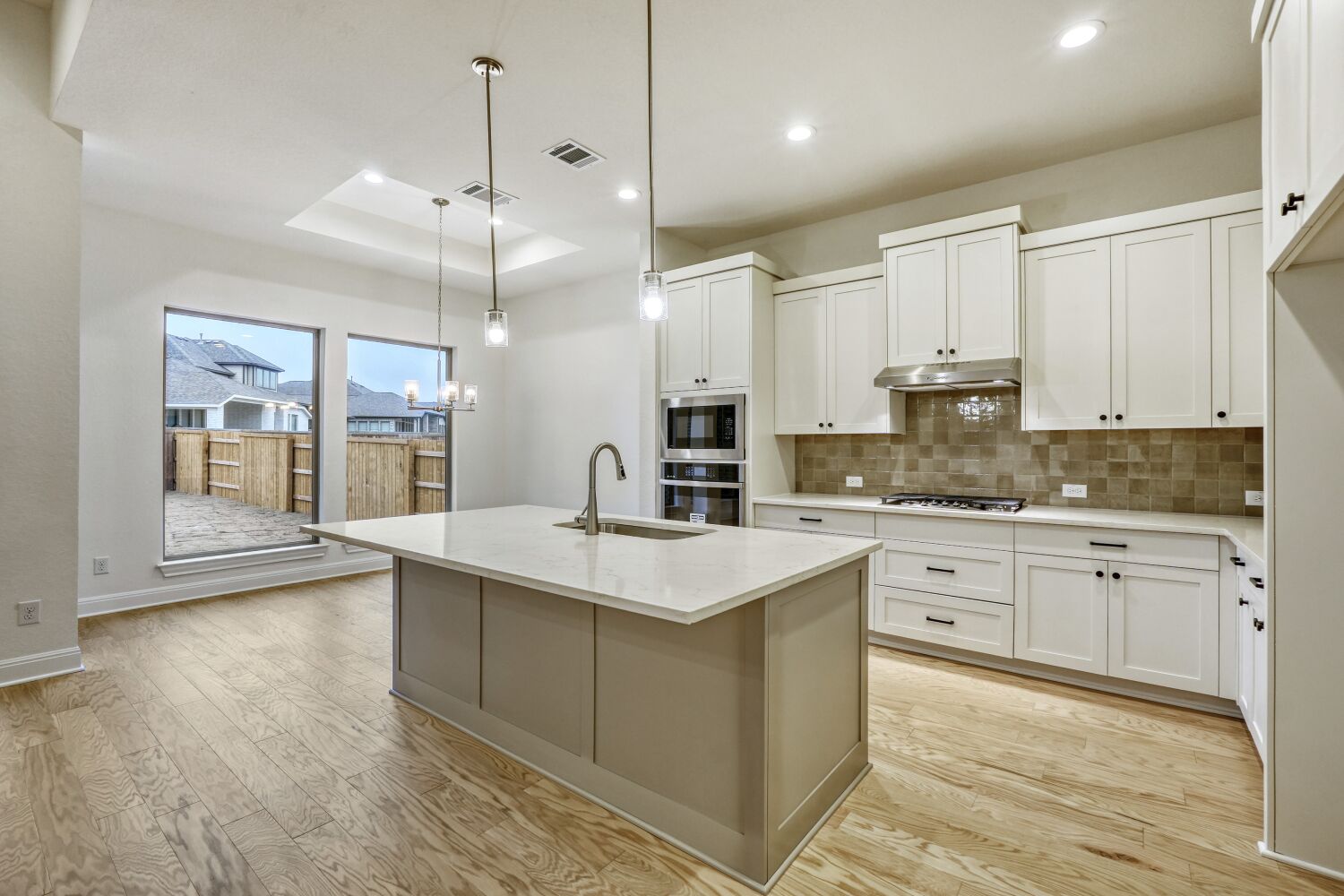 253 Prickly Poppy Loop Kyle, TX 78640 - Photo 4 of 11 a kitchen with stainless steel appliances granite countertop a sink a stove and white cabinets with wooden floor