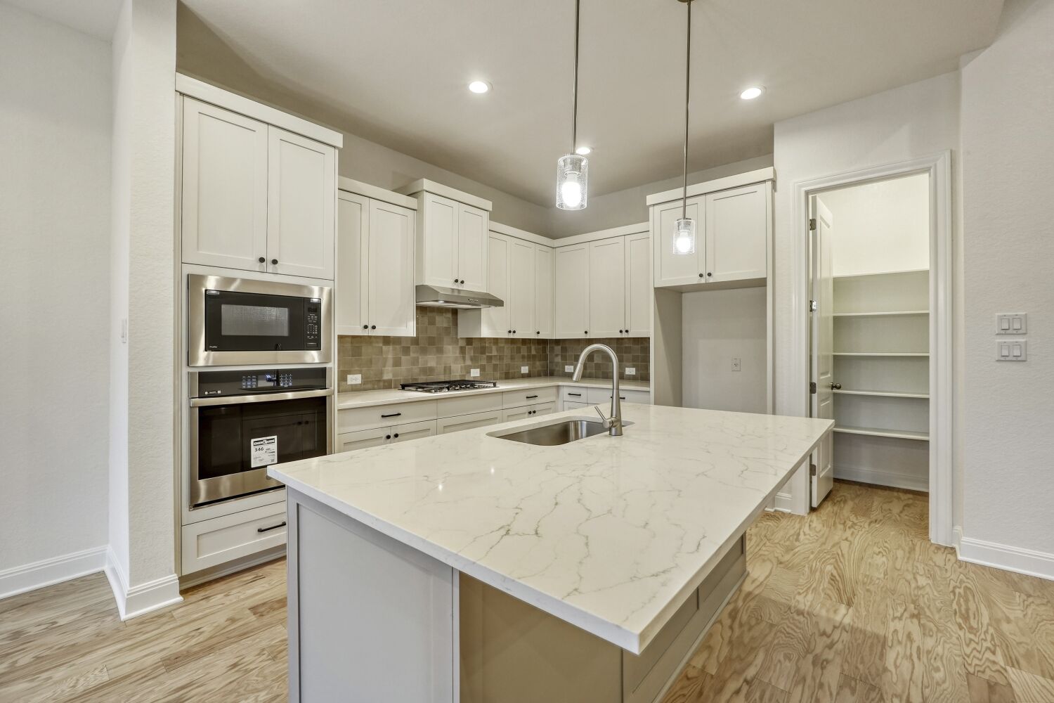 253 Prickly Poppy Loop Kyle, TX 78640 - Photo 5 of 11 a kitchen with stainless steel appliances a stove refrigerator sink and microwave