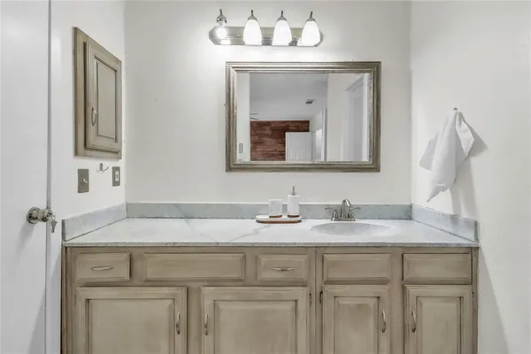 a bathroom with a granite countertop sink a toilet and shower