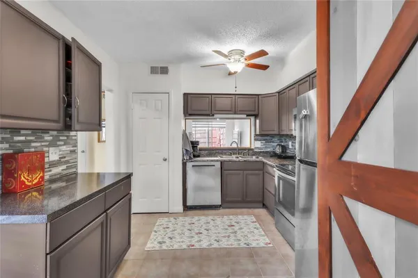 a kitchen with stainless steel appliances granite countertop a sink stove and refrigerator