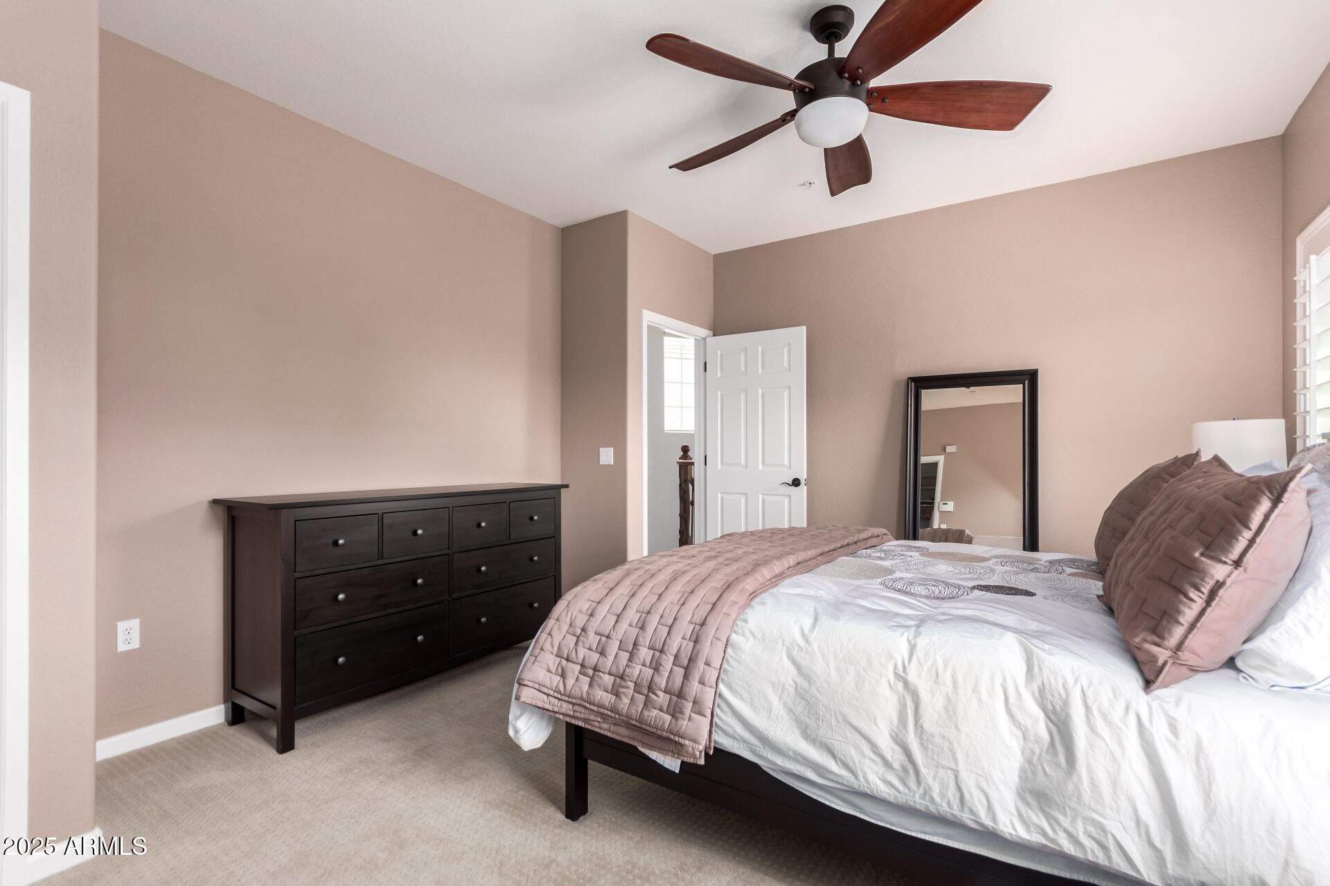 3935 East Rough Rider Road, Unit 1197 Phoenix, AZ 85050 - Photo 13 of 31 a bedroom with a bed and a ceiling fan