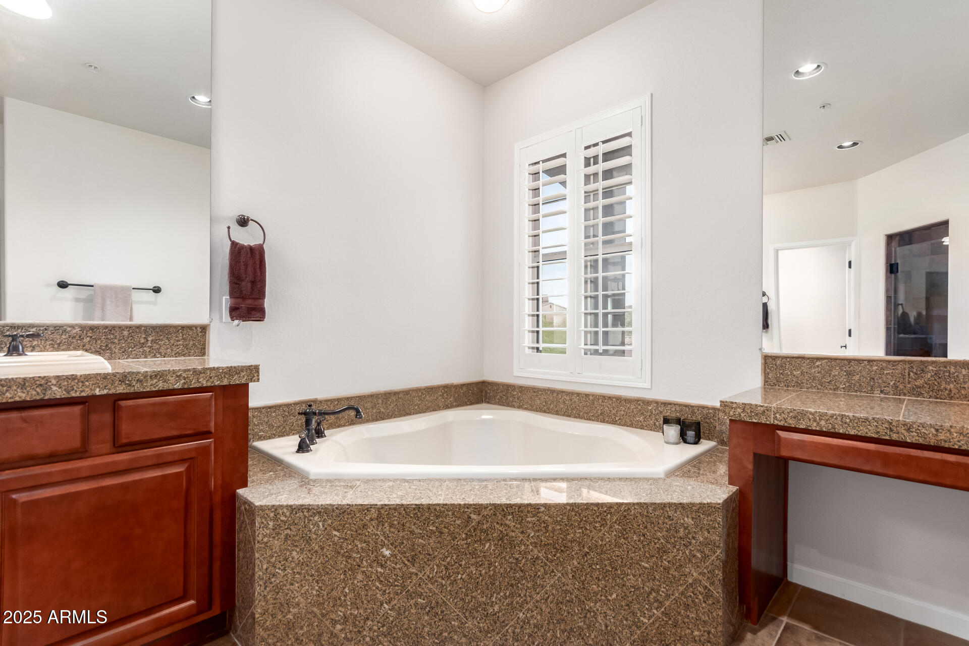 3935 East Rough Rider Road, Unit 1197 Phoenix, AZ 85050 - Photo 16 of 31 a bath tub sitting next to a granite countertop sink and a mirror