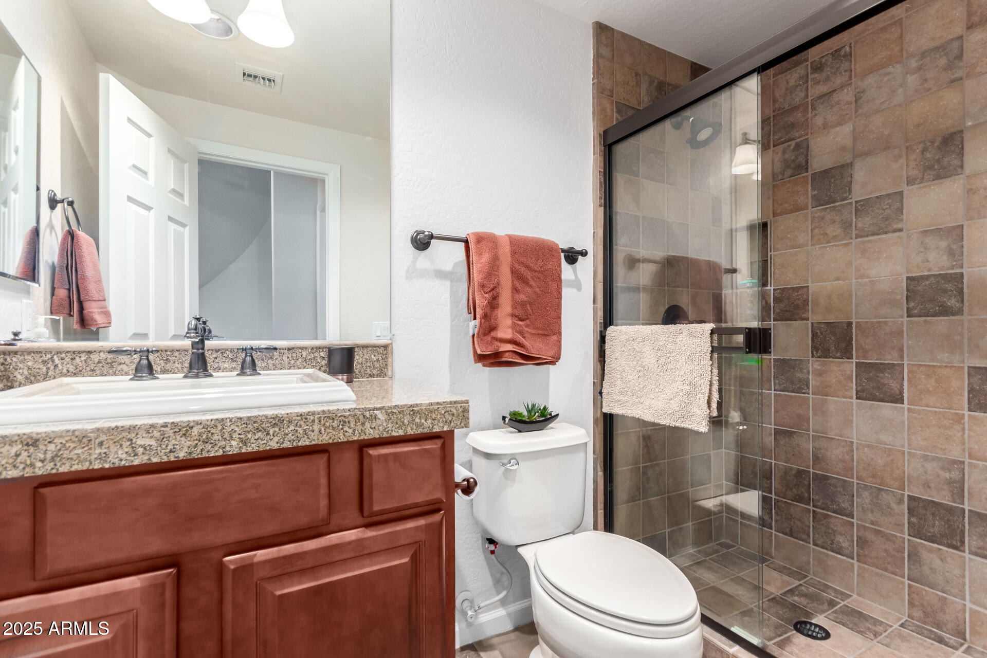 3935 East Rough Rider Road, Unit 1197 Phoenix, AZ 85050 - Photo 21 of 31 a bathroom with a granite countertop sink mirror vanity and toilet
