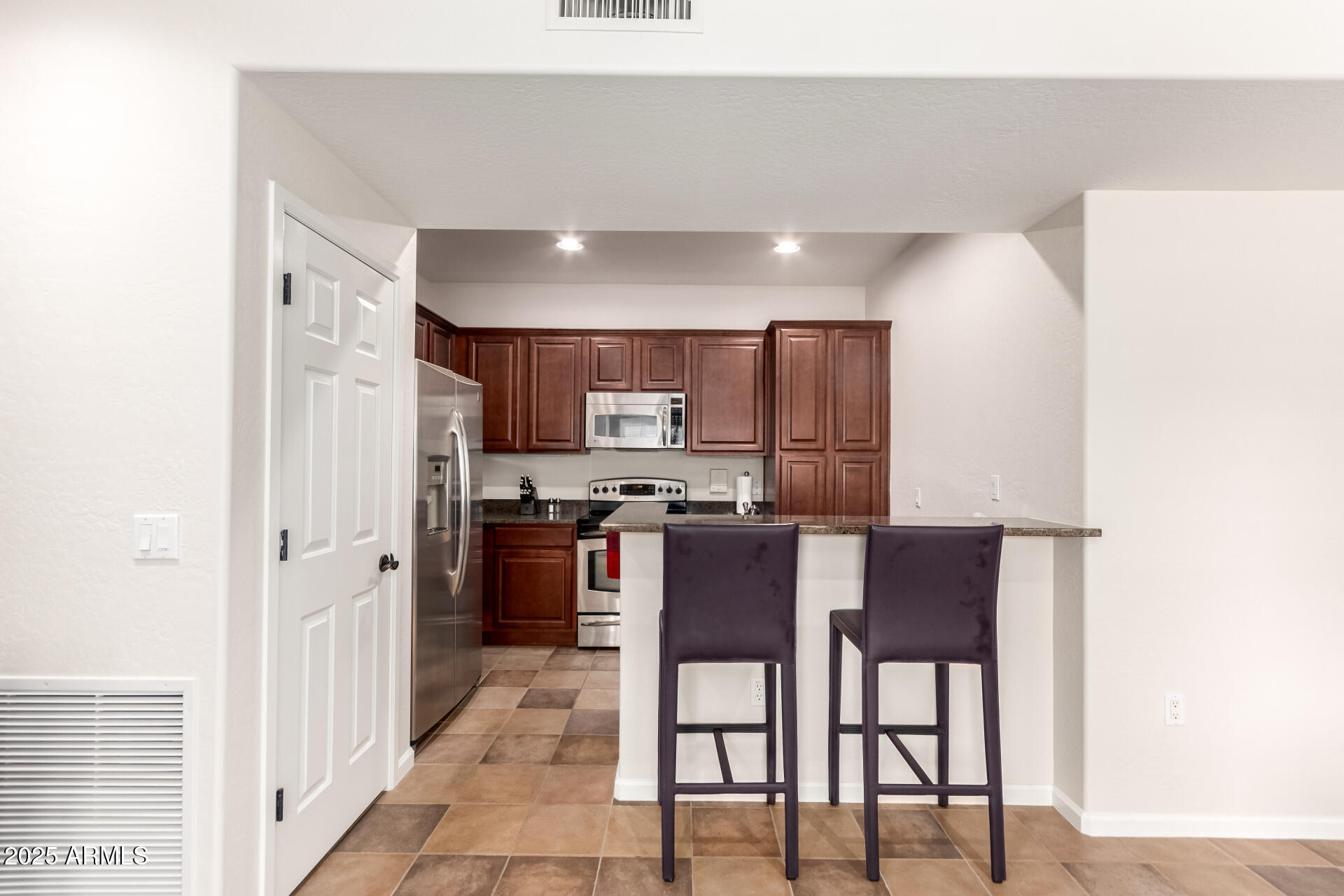3935 East Rough Rider Road, Unit 1197 Phoenix, AZ 85050 - Photo 8 of 31 a kitchen with stainless steel appliances kitchen island granite countertop a refrigerator a stove a sink with a dining table and chairs