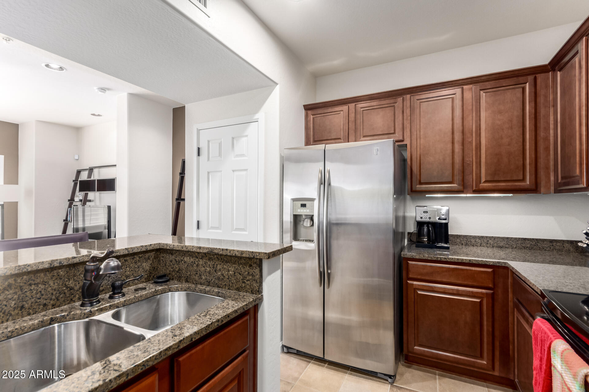 3935 East Rough Rider Road, Unit 1197 Phoenix, AZ 85050 - Photo 10 of 31 a kitchen with stainless steel appliances granite countertop a refrigerator a sink a stove a oven with wooden cabinets and floor