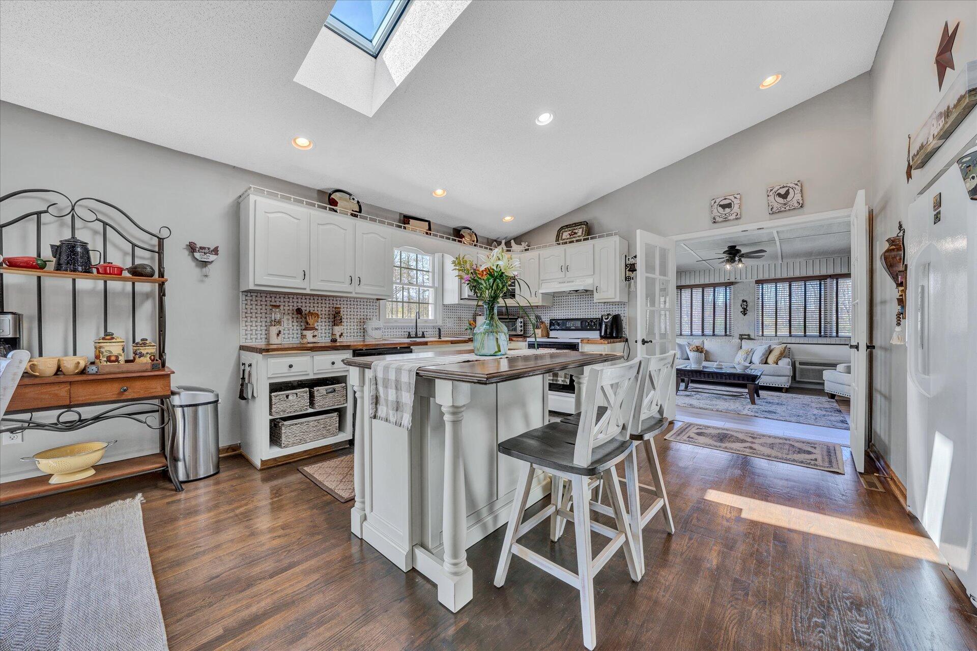 1077 Hopkins Road Rocky Mount, VA 24151 - Photo 23 of 69 a kitchen with stainless steel appliances kitchen island granite countertop a table chairs cabinets and wooden floor
