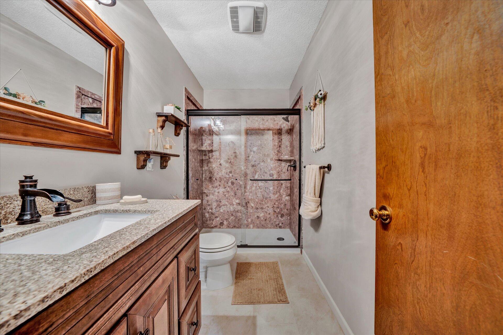 1077 Hopkins Road Rocky Mount, VA 24151 - Photo 30 of 69 a bathroom with a granite countertop sink a mirror and shower