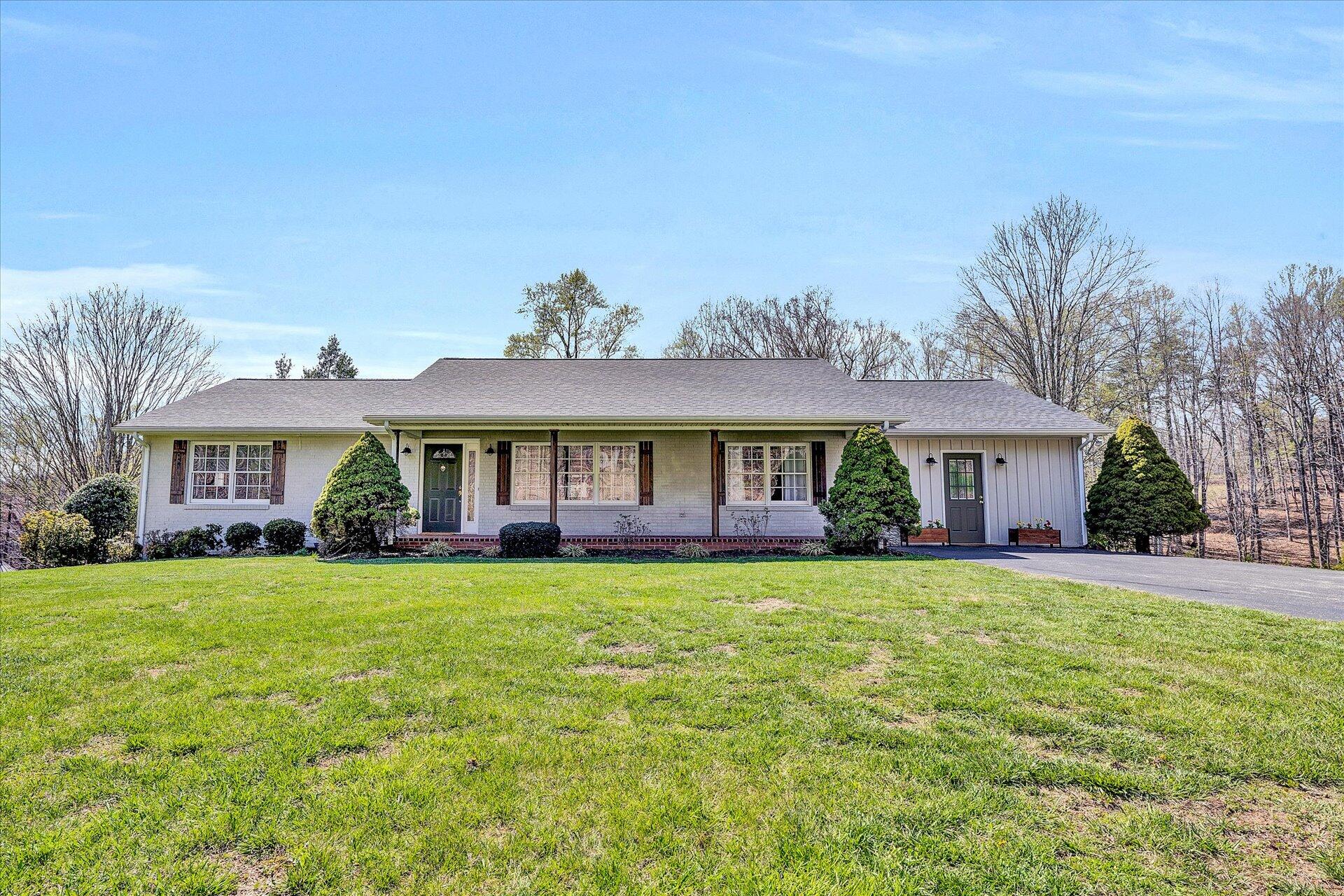 1077 Hopkins Road Rocky Mount, VA 24151 - Photo 5 of 69 a front view of a house with a garden