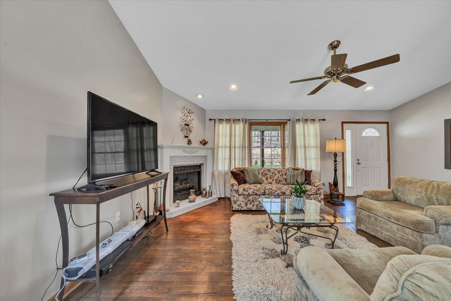 1077 Hopkins Road Rocky Mount, VA 24151 - Photo 9 of 69 a living room with furniture a fireplace and a chandelier
