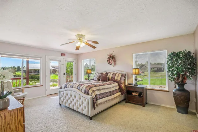 a view of a house with a yard and table and chairs under an umbrella