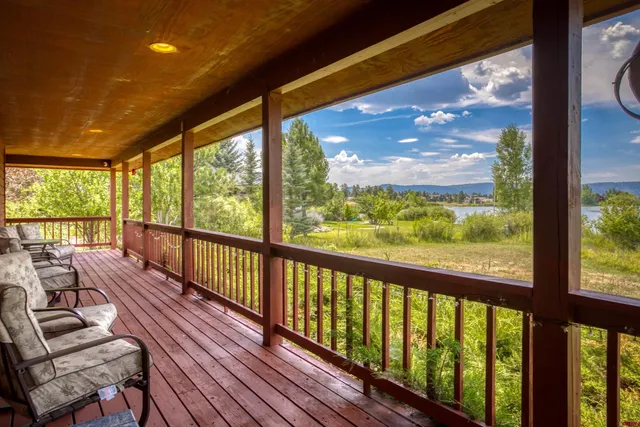 a front view of house with yard and trees in the background