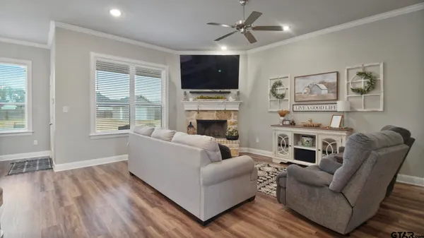 a living room with furniture a flat screen tv and a fireplace