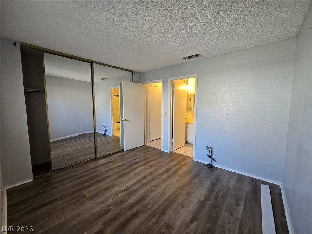 6750 Del Rey Avenue, Unit 133 Las Vegas, NV 89146 - Photo 14 of 34 Functional bedroom featuring a mirrored closet and durable flooring for modern living.
