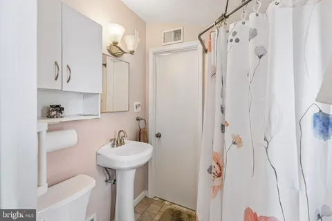 a bathroom with a sink a toilet and a mirror