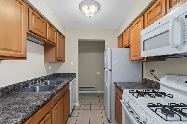 a kitchen with granite countertop a stove and a wooden cabinets