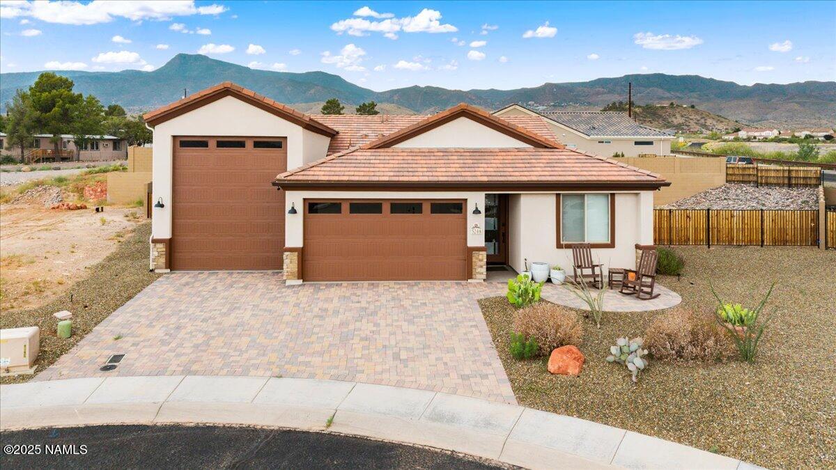 a front view of a house with yard and mountain view