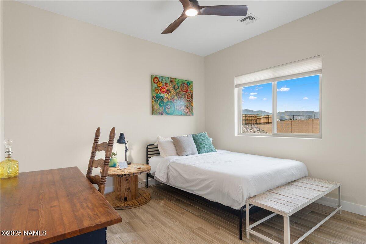 524 Powder Box Road Clarkdale, AZ 86324 - Photo 20 of 32 a bedroom with a bed and wooden floor