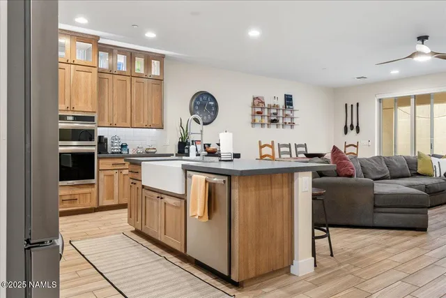 a kitchen with stainless steel appliances granite countertop a refrigerator a sink and a stove