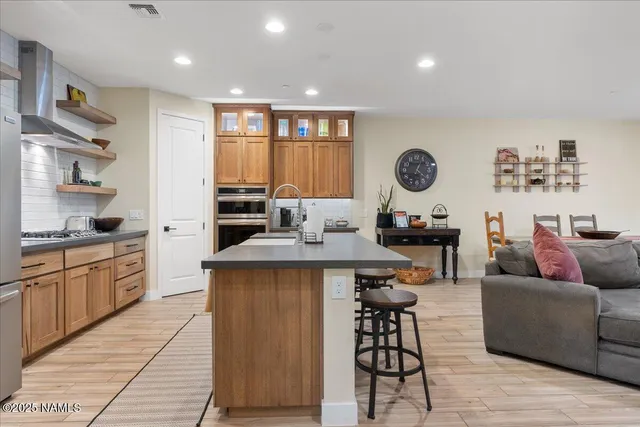 a living room with stainless steel appliances kitchen island granite countertop furniture a rug and a window