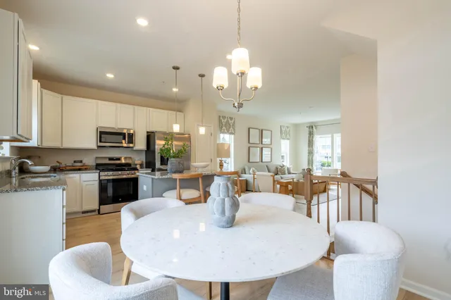 a dining room with wooden floor a chandelier a wooden table and chairs
