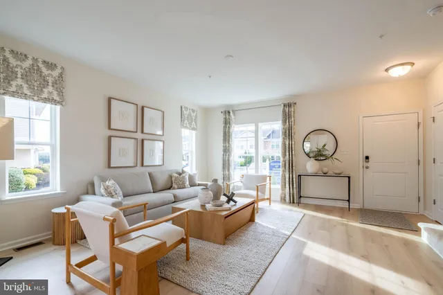 a living room with furniture a wooden floor and a window
