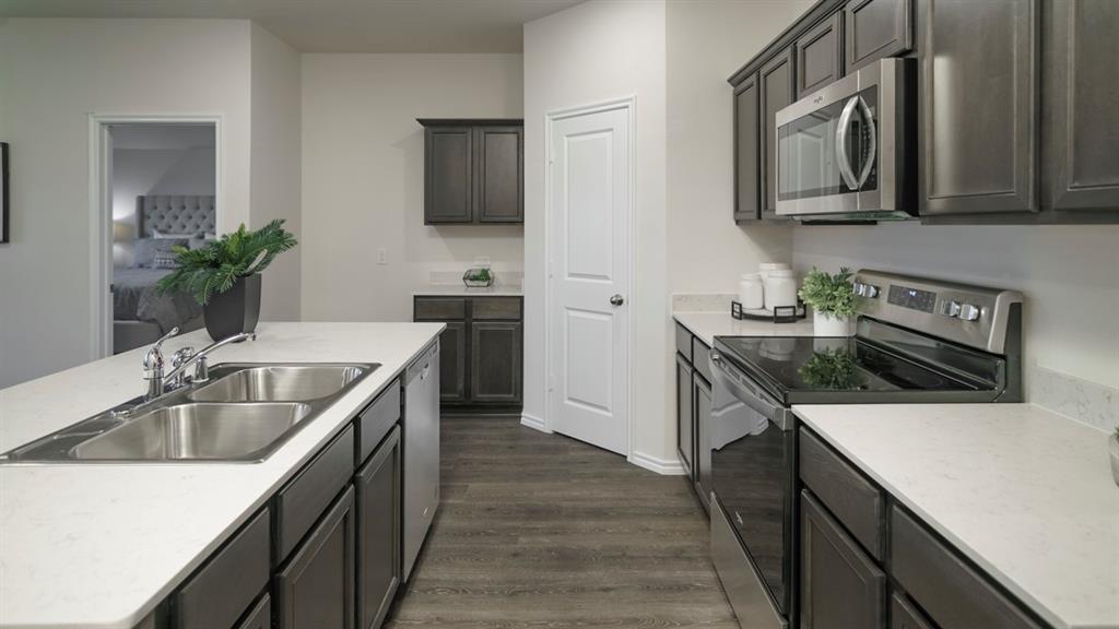 3100 Charleston Drive Ennis, TX 75119 - Photo 12 of 23 Modern kitchen featuring a double basin stainless steel sink, a stainless steel dishwasher, and dark wood-finish cabinetry