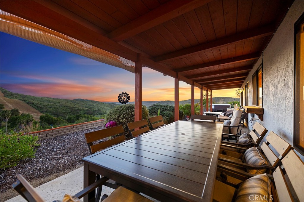 4613 Sleeping Indian Road Fallbrook, CA 92028 - Photo 7 of 75 a view of a patio with dining table and chairs with a couches near an umbrella