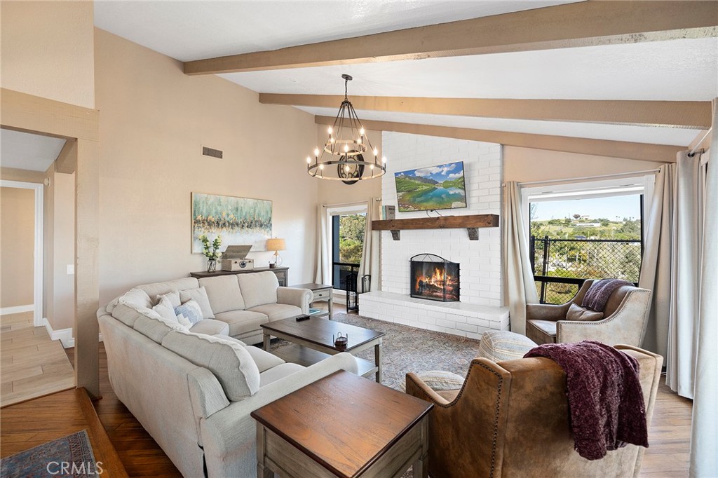 4613 Sleeping Indian Road Fallbrook, CA 92028 - Photo 9 of 75 a living room with furniture a fireplace and a floor to ceiling window