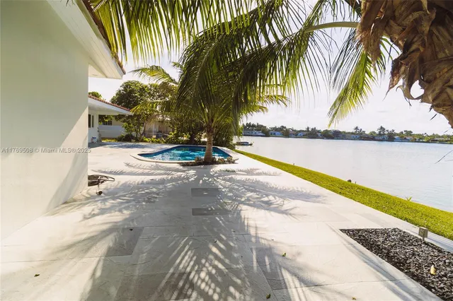 a swimming pool with a yard and palm trees