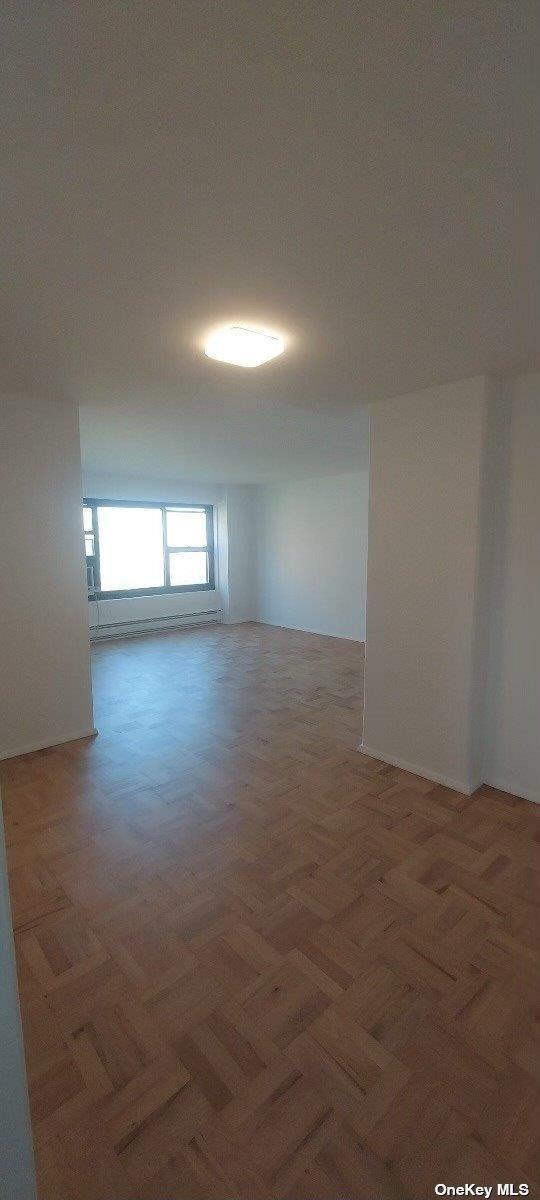 21-20 33rd Road, Unit 9C Queens, NY 11106 - Photo 1 of 9 an empty room with wooden floor and windows