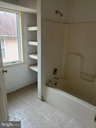 a view of a bedroom with wooden floor and windows