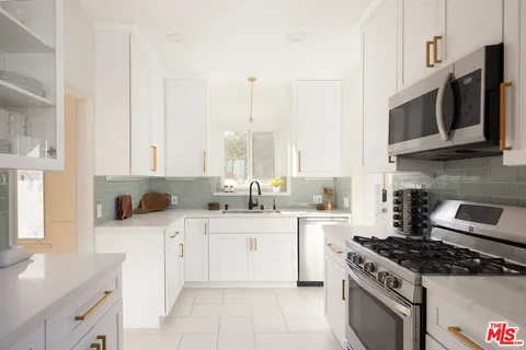 a kitchen with stainless steel appliances a stove a sink and a microwave