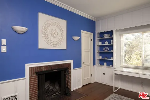 a view of an empty room with a fireplace and a window
