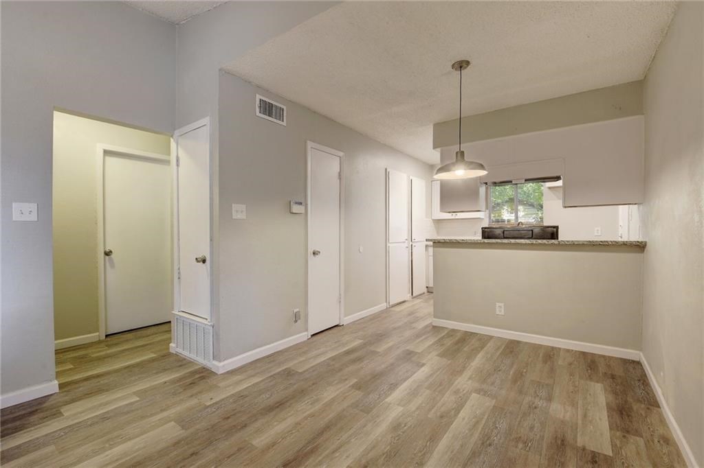 2311 Teri Road, Unit B Austin, TX 78744 - Photo 6 of 25 a view of a kitchen with a sink and dishwasher a refrigerator with wooden floor