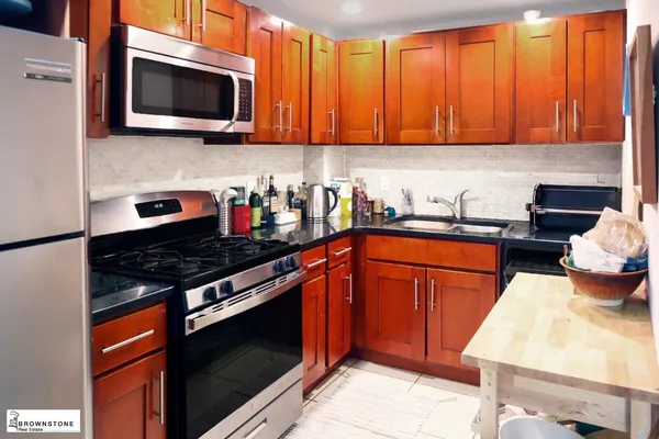 a kitchen with stainless steel appliances granite countertop a stove microwave and sink