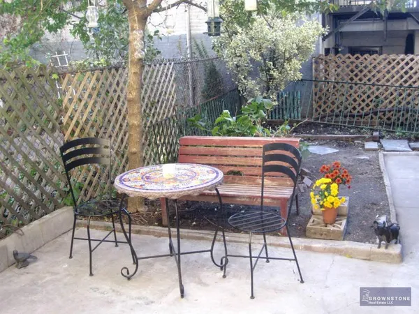 a view of a chairs and table in backyard