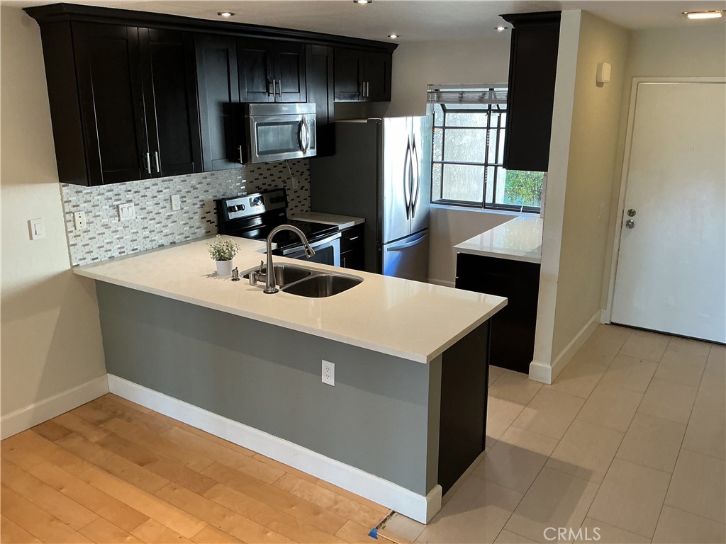 251 Pineview Irvine, CA 92620 - Photo 2 of 54 a kitchen with a sink a counter top space and stainless steel appliances
