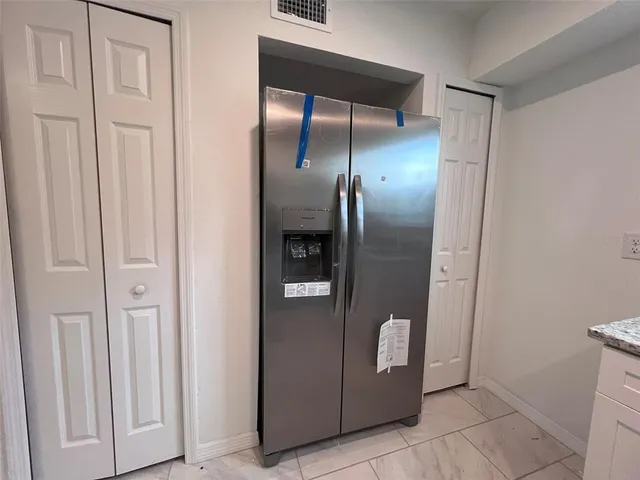 a kitchen with granite countertop a stove a sink and a microwave