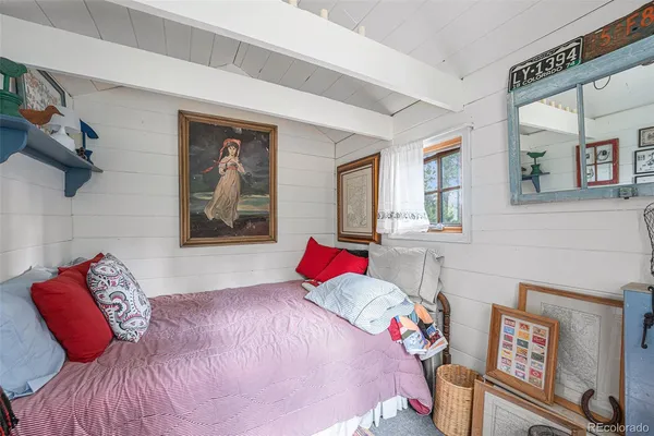 a bedroom with a bed and a painting on the wall