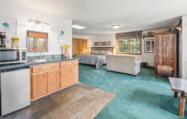 a kitchen with a sink dishwasher a stove a dining table and chairs with wooden floor