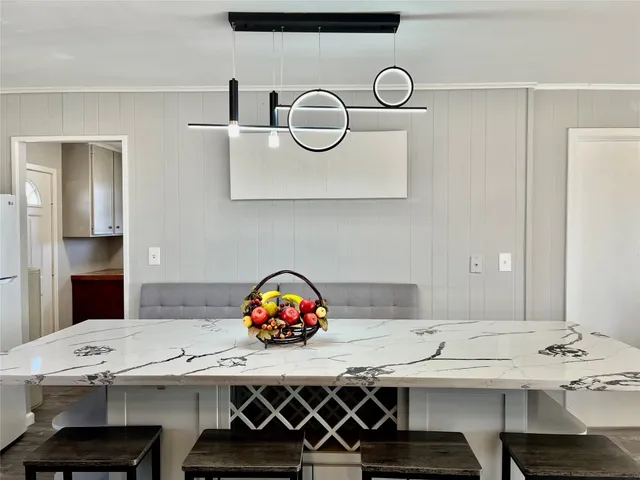 a large white kitchen with granite countertop a sink and cabinets