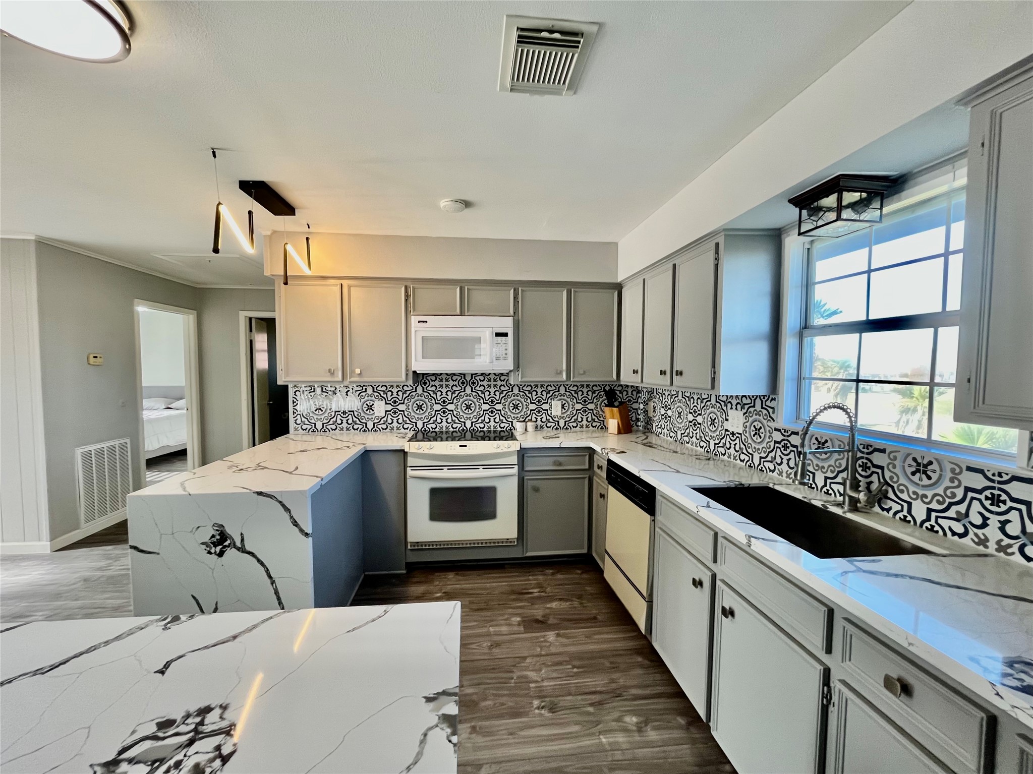 610 Seashell Drive Surfside Beach, TX 77541 - Photo 19 of 42 a large white kitchen with granite countertop a sink and cabinets