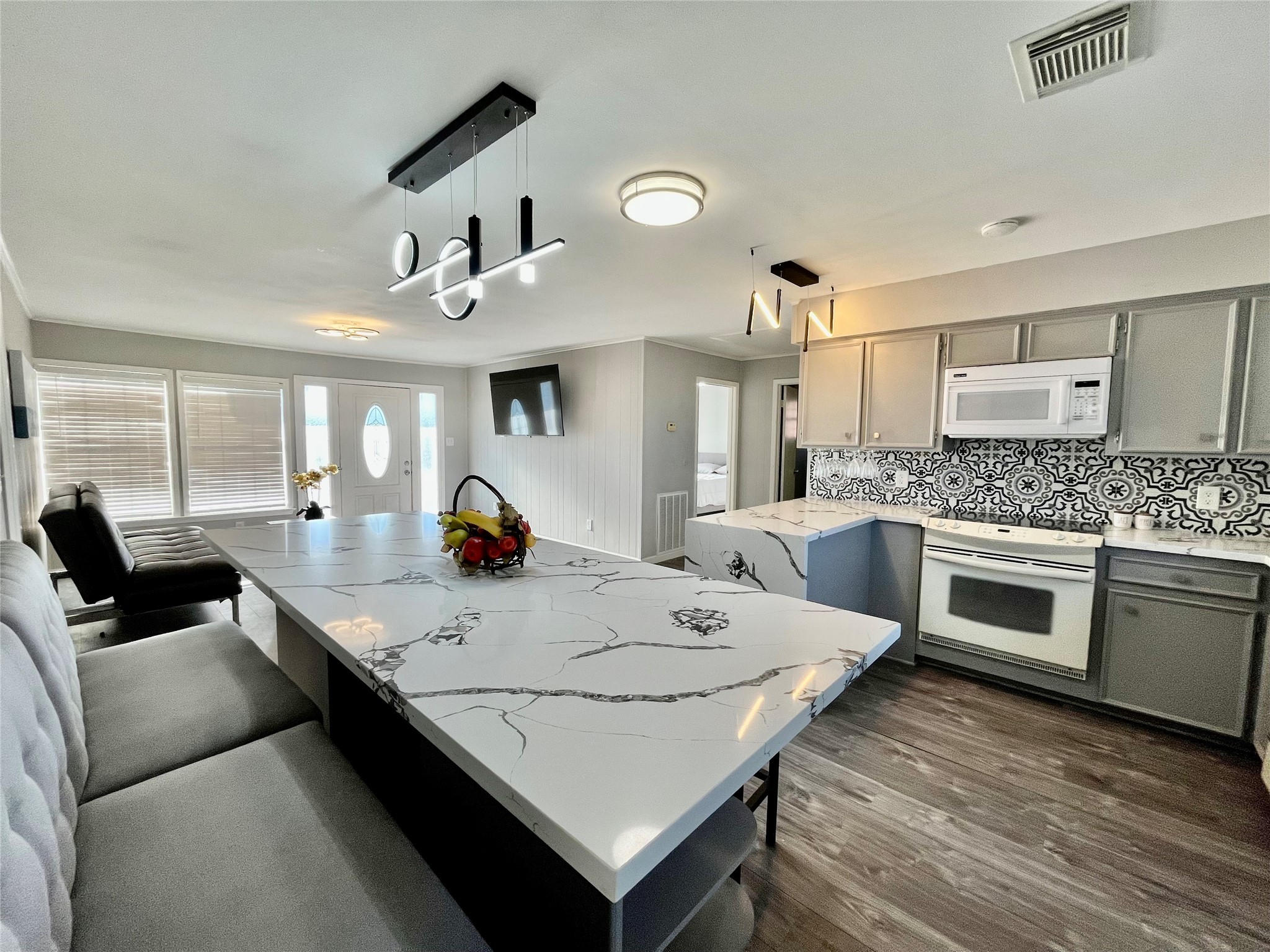 610 Seashell Drive Surfside Beach, TX 77541 - Photo 21 of 42 a large white kitchen with a stove a sink a refrigerator and dining table with wooden floor