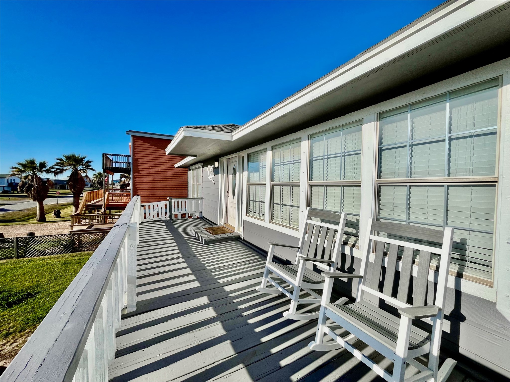610 Seashell Drive Surfside Beach, TX 77541 - Photo 6 of 42 a view of a patio with table and chairs with wooden floor and fence