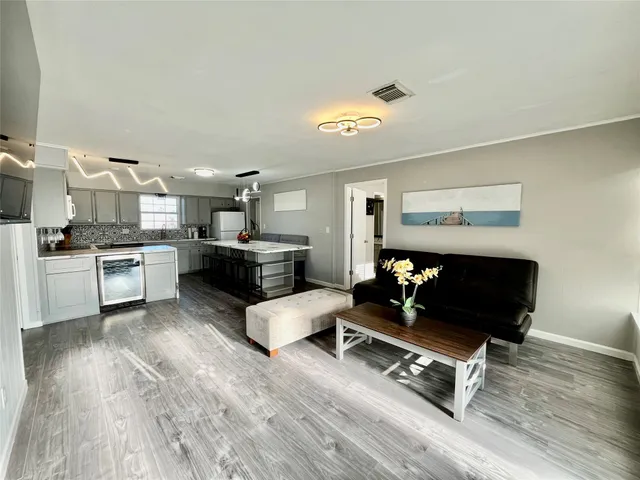 a living room with furniture and kitchen view