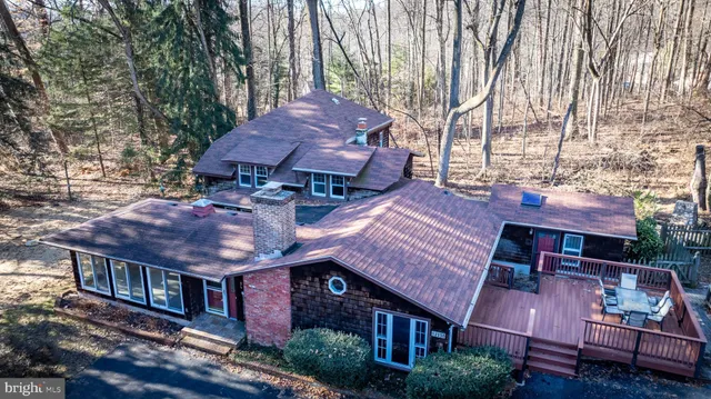 a view of a house with wooden deck front of house